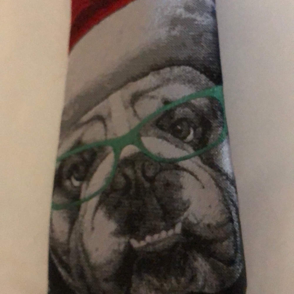 Dog with red hat on black tie , white snowflakes